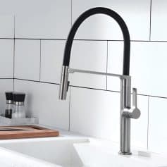 Brushed stainless steel kitchen faucet with black rubber hose and modern design, mounted on white tiled wall backdrop. Perfect for contemporary kitchen decor and water efficiency.