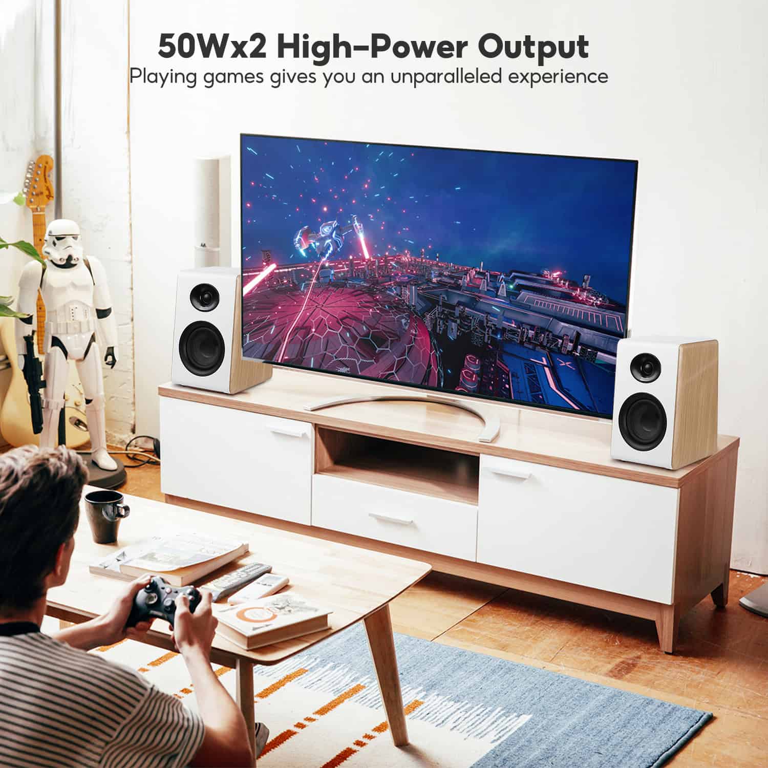 High-power wireless speakers on a modern entertainment center with a curved TV displaying a sci-fi game scene, in a cozy living room setup.