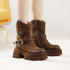 Brown leather ankle boots with chunky soles, stylish zipper detail, and decorative buckle, ideal for fashion-forward footwear. Perfect for casual or trendy outfits, offering comfort and durability.