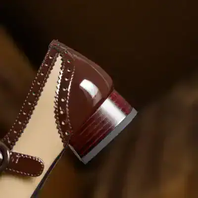 Brown leather shoe with decorative perforations and a chunky wooden heel, showcasing stylish footwear from Monalisa Store.