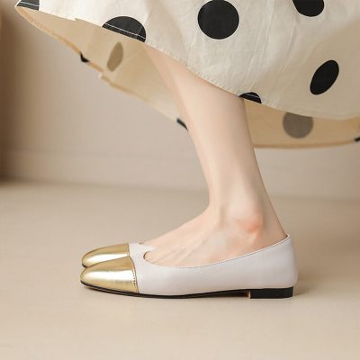 Gold-cap-toe-flats-women-s-fashion-shoes 2. Elegant white ballet flats with gold toe caps, perfect for stylish women looking for comfort and sophistication. Ideal for casual or dressy occasions. 3. Close-up of stylish women's ballet flats featuring a sleek white design with eye-catching gold toe caps, combining comfort with modern fashion. Perfect addition to any wardrobe. 4. The image showcases a woman's foot wearing fashionable white ballet flats with gold toe caps, highlighting a chic and elegant footwear choice suitable for various outfits and events. 5. relevant.