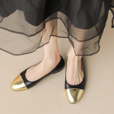 Black and gold ballet flats on a woman's feet wearing a sheer black skirt, showcasing stylish comfortable footwear from Monalisa Store, perfect for fashionable eyestrain or eyeglasses shoppers.
