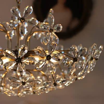 Elegant crystal chandelier with flower-shaped design, enhancing the luxurious ambiance of Monalisa Store for premium optical and aesthetic services.