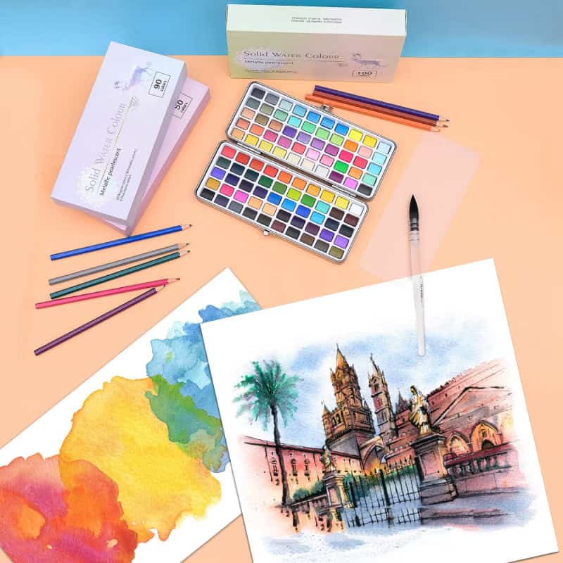 Colorful watercolor paints and brushes on pastel background showcasing artistic tools at Monalisa Store for watercolor art enthusiasts.