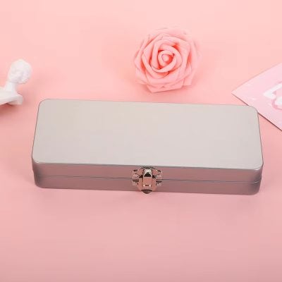 Metal storage box with pink accents on a pink background, surrounded by soft decorative items; suitable for cosmetics, jewelry, or optical accessories at Monalisa Store.