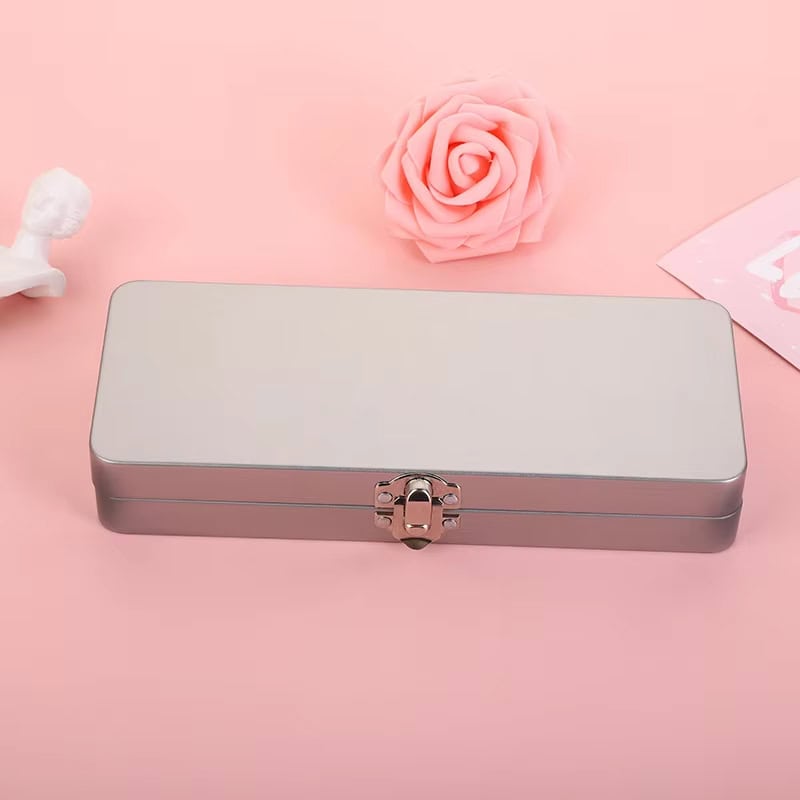 Metal storage box with pink accents on a pink background, surrounded by soft decorative items; suitable for cosmetics, jewelry, or optical accessories at Monalisa Store.
