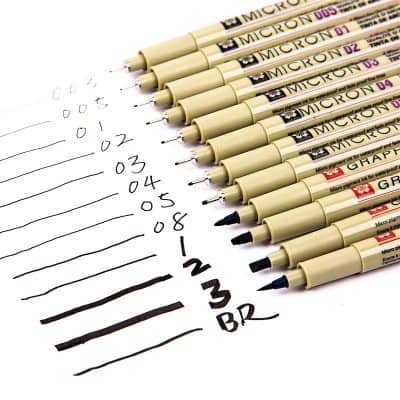 Fine tip black and colored Micron pens for detailed writing and drawing, displayed on paper with sample lines and notes.