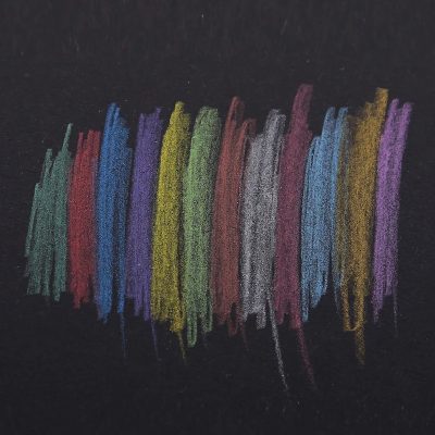 Multicolored chalks on black chalkboard, vibrant artistic background, educational and creative theme for school or art projects, colorful chalk drawing representing artistic expression and learning.