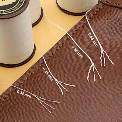 Fine gauge embroidery thread, 0.45mm, displayed on fabric with precise measurement labels, ideal for detailed sewing projects and professional textile work.