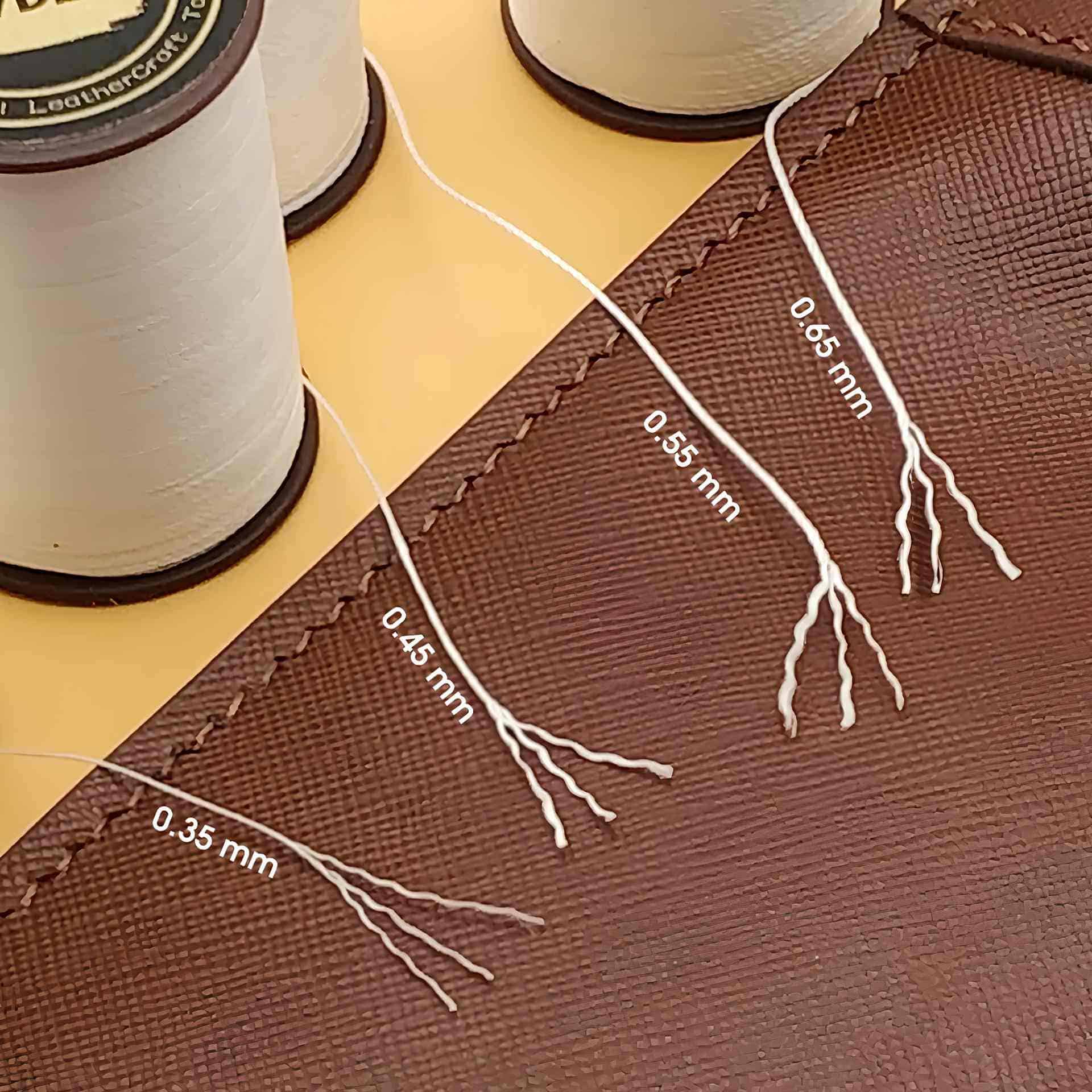 Fine gauge embroidery thread, 0.45mm, displayed on fabric with precise measurement labels, ideal for detailed sewing projects and professional textile work.