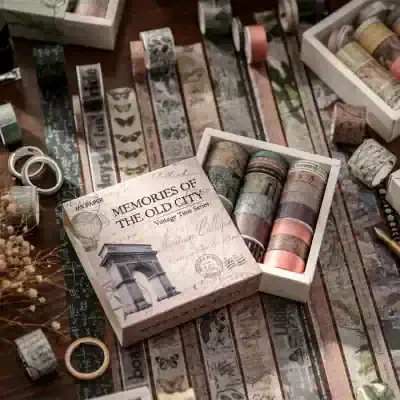 Vintage decorative washi tapes with Parisian and Eiffel Tower designs, perfect for scrapbooking, journaling, and crafts. Beautifully arranged in a white box, highlighting a nostalgic and artistic aesthetic.