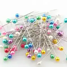 Colorful sewing pins with plastic round heads for dressmaking, tailoring, and crafting projects. Bright, assorted colors including pink, blue, yellow, white, purple, red, and green, perfect for fabric pins.