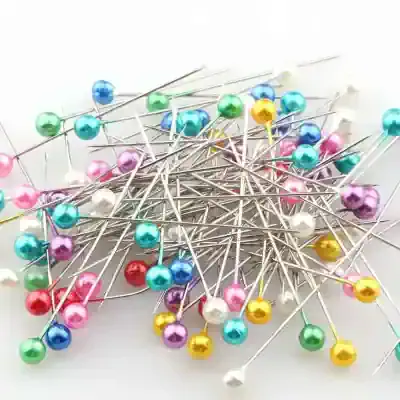 Colorful sewing pins with plastic round heads for dressmaking, tailoring, and crafting projects. Bright, assorted colors including pink, blue, yellow, white, purple, red, and green, perfect for fabric pins.