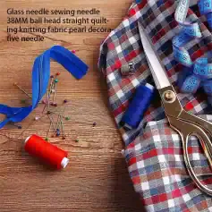 Colorful sewing pins, scissors, measuring tape, and fabric on wooden surface, ideal for embroidery and tailoring supplies at Monalisa Store.