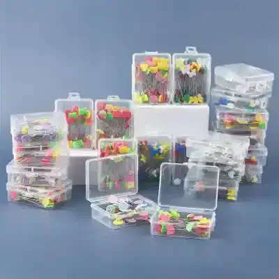 Buttons storage boxes, sewing pins, and craft organizing containers for needlework and DIY projects.
