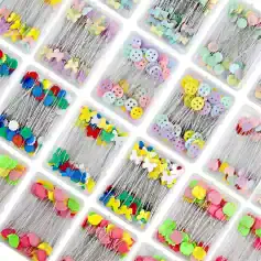 Colorful decorative sewing pins with heart, butterfly, and button designs for craft and sewing projects, arranged in clear plastic containers.