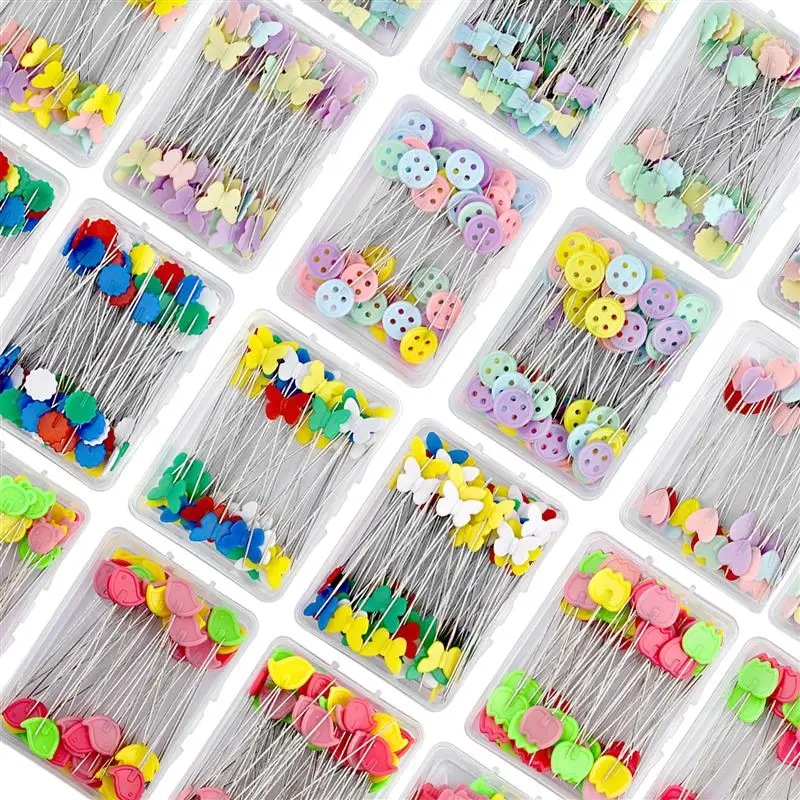 Colorful decorative sewing pins with heart, butterfly, and button designs for craft and sewing projects, arranged in clear plastic containers.