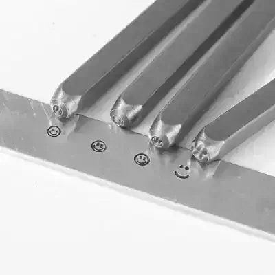 Metal dental tools with smiley face engraved on handles, used in cosmetic and general dentistry procedures. Precision dental instruments for professional dental clinics and oral health care.