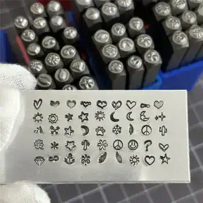 Miniature tattoo stamps with various symbols including hearts, stars, moons, peace signs, and flowers, ideal for creating tiny tattoo designs or nail art.