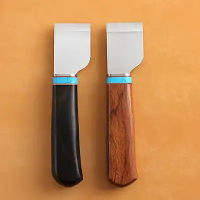 Butcher knives with wooden and black handles on orange background.