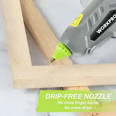 Battery-powered glue gun applying adhesive to wood piece for furniture repair or assembly.