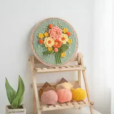 Colorful embroidered floral embroidery hoop art displayed on a wooden stand, ideal for home decor and craft enthusiasts. High-quality textile art piece perfect for adding a touch of elegance to any room.
