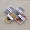 Shiny gold, silver, black, and rose gold colored dressmaking pins in transparent plastic containers for sewing and tailoring crafts.