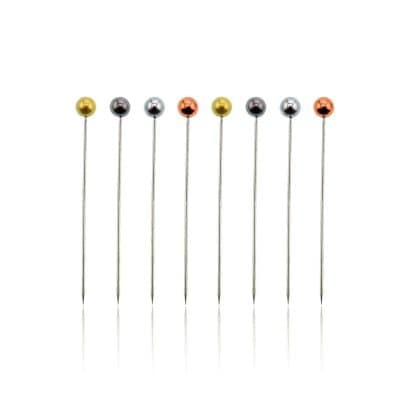 Colorful metal sewing pins with round heads for fabric and textile crafts, also used in sewing and tailoring. Perfect accessories for dressmakers and hobbyists.