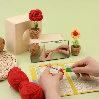 Brightly colored crochet flower decorations with crafting tools, yarn, and a smartphone, showcasing DIY crochet crafts and knitting hobby ideas at Monalisa Store.