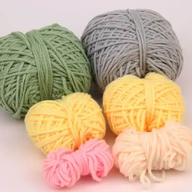 Green, gray, yellow, pink, and white yarn balls for knitting or crochet, colorful yarn collection for crafts and knitting projects, soft and thick yarn suitable for creating warm garments and accessories, ideal for DIY knitting lovers and craft enthusiasts.