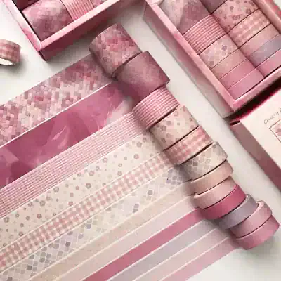 Pink washi tape collection for decorating and crafting, featuring various shades and patterns including floral, checkered, and geometric designs, ideal for beautifying gift wrapping and DIY projects.