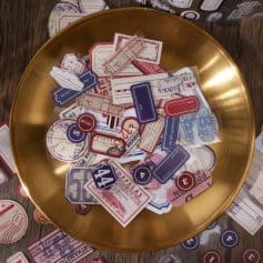 Dispenser tray with vintage travel tickets, boarding passes, and luggage tags, emphasizing travel accessories and nostalgia.