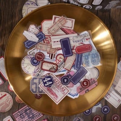 Dispenser tray with vintage travel tickets, boarding passes, and luggage tags, emphasizing travel accessories and nostalgia.
