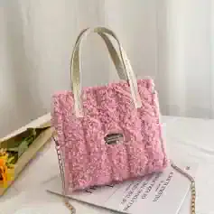 Pink fluffy faux fur handbag with metallic handles and chain strap, stylish and trendy accessory for women’s fashion.