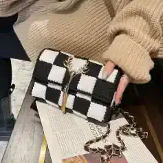 Checkered black and white designer handbag with gold crab embellishment and chain strap, perfect for fashion-forward accessories enthusiasts.
