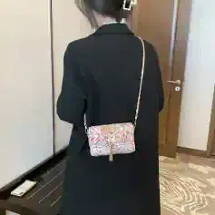 Elegant floral patterned crossbody clutch bag with zipper and tassel, perfect for accessory enhancement and casual to formal outfits.