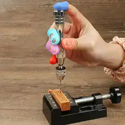 Precise dental drill with colorful grip guards on a wooden surface, mounted on a black dental device for stability, used for dental procedures and restorations.