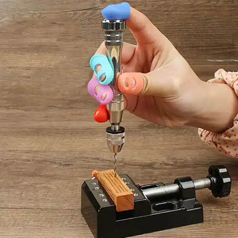 Precise dental drill with colorful grip guards on a wooden surface, mounted on a black dental device for stability, used for dental procedures and restorations.