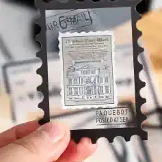 Airmail stamp art with vintage building illustration, transparent frame, and postal markings, displayed at Monalisa Medical Store for unique optical accessories.