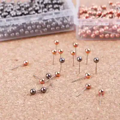 Elegant metal push pins with rose gold and black finishes, ideal for organizing and decorating office or home bulletin boards, ensuring a sleek appearance.