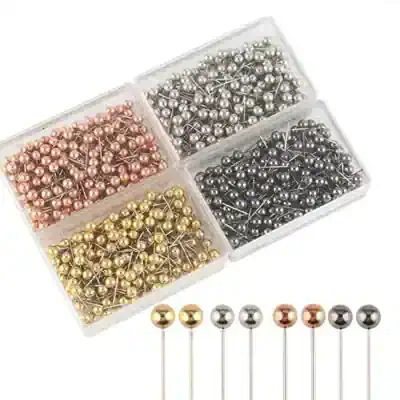 Colorful metallic sewing pins organized in a plastic container, suitable for craft and sewing projects.