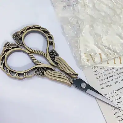 Vintage gold-colored eyelash extension scissors with intricate decorative detailing, ideal for professional eyelash and eyelash extension applications.