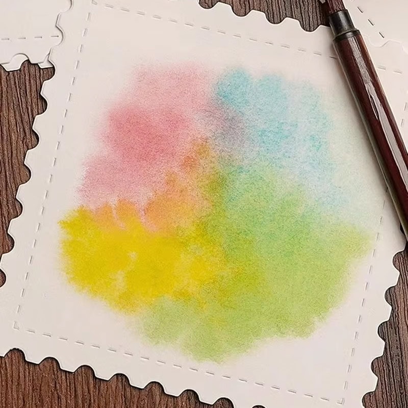 Colorful watercolor on a white textured paper with decorative edges, placed on a wooden surface with a brown pen nearby, embodying artistic creativity and vibrant expression for optical health and wellness.