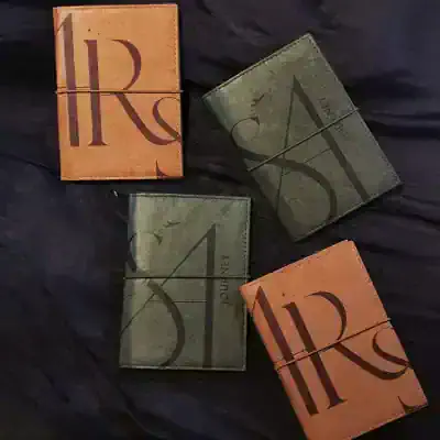 Leather wallets with bold R and S initials on dark fabric background, stylish accessories for men and women.