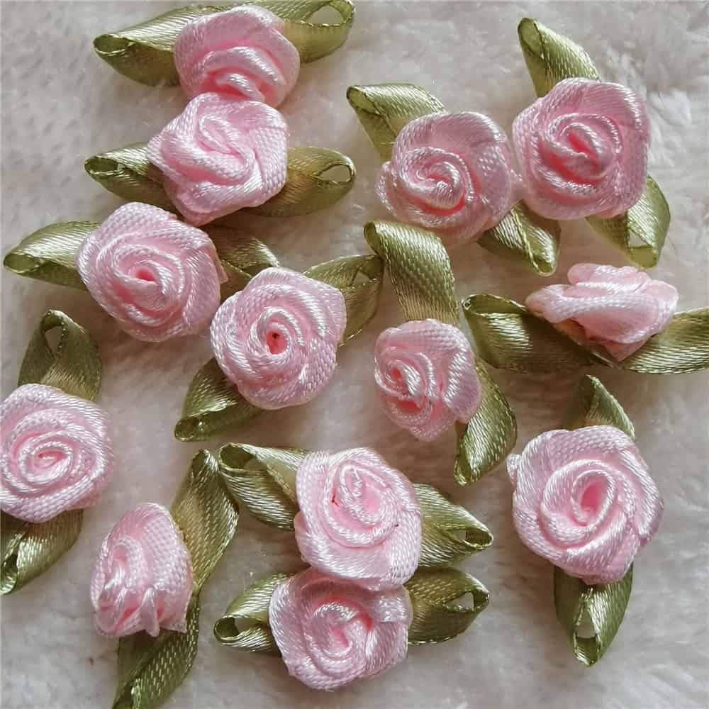 Pink satin rose appliqué embellishments with green satin leaves for clothing, accessories, or craft projects. Perfect for adding a floral touch to garments, decorations, and DIY fashion designs.