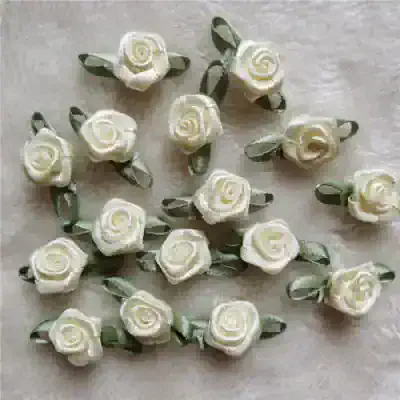 Delicate ivory satin rose hair clips with green leaves, perfect for bridal or special occasion accessories. Handmade floral hair embellishments for elegant styling.