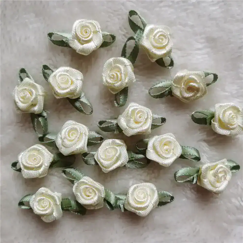 Delicate ivory satin rose hair clips with green leaves, perfect for bridal or special occasion accessories. Handmade floral hair embellishments for elegant styling.