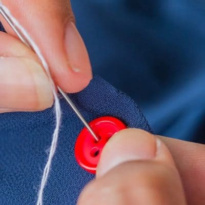 Button sewing needle plucking red button sewing factory for clothing and accessories.