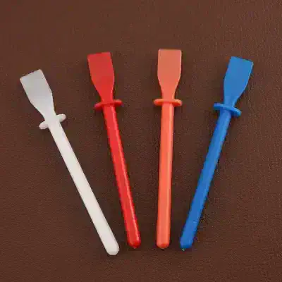 Disposable eyelash extension applicator tools in white, red, pink, and blue for precise eyelash extension application.