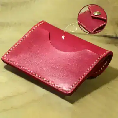 Red leather money clip wallet with stitching details and snap button closure for men's fashion and accessories.
